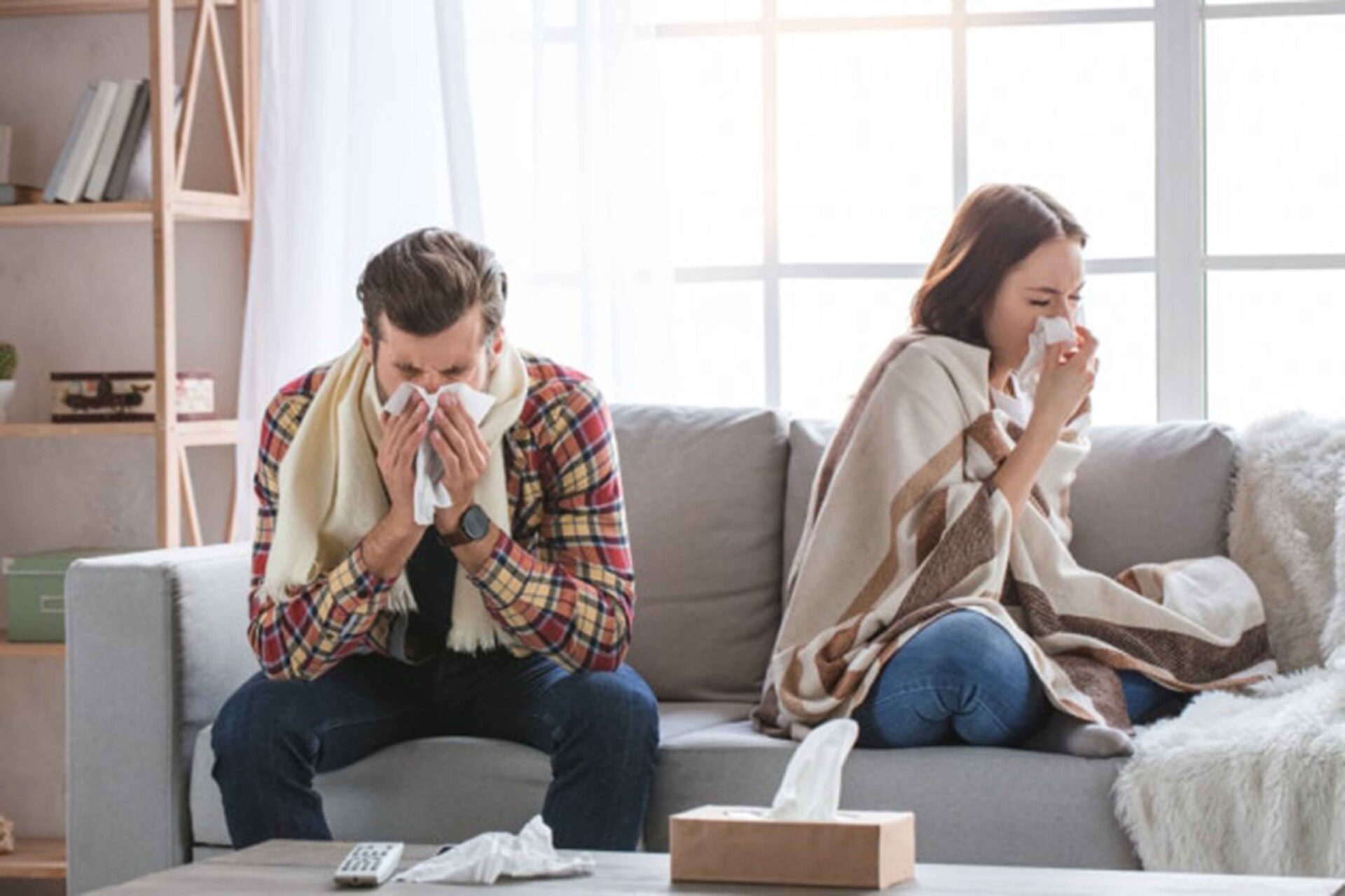 a couple sitting on the couch looks sick because of indoor air quality