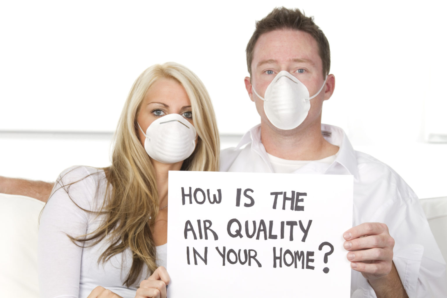a couple wearing mask with banner in their hands, "how is the air quality in your home" is written on the banner.